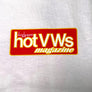 A close-up of a white fabric garment featuring a red rectangular graphic patch with yellow and white text that reads 'dune buggies and hot VWs magazine'.