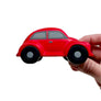 Red toy car held by a hand on a white background